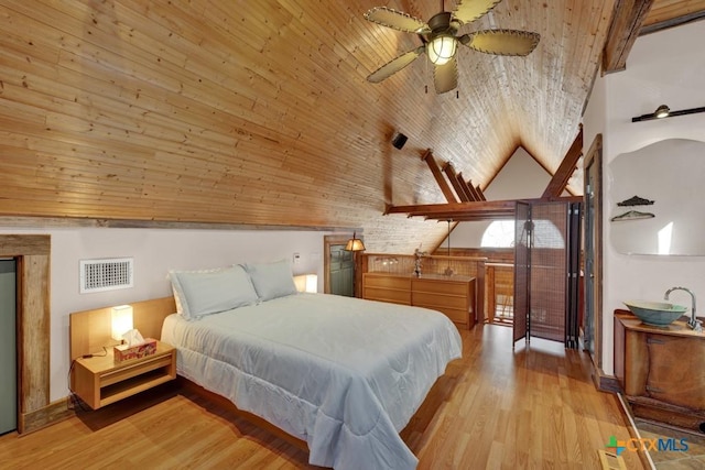 bedroom with vaulted ceiling, wooden ceiling, and light wood-type flooring