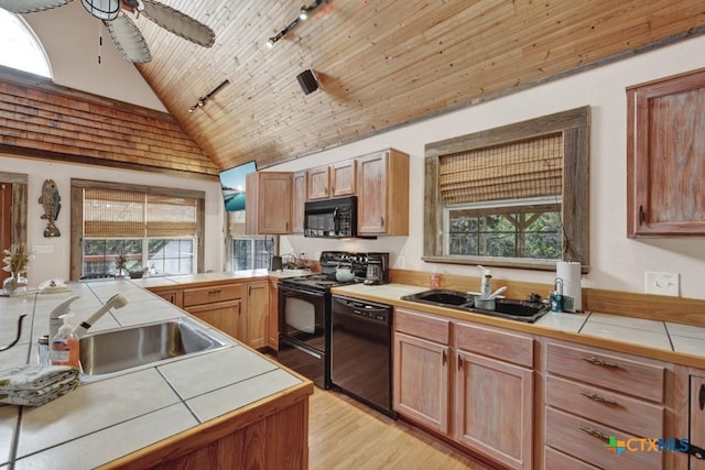 kitchen featuring tile counters, sink, and black appliances