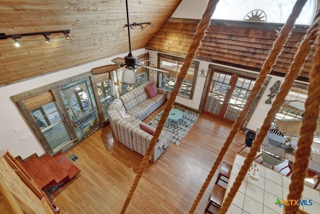 living room with hardwood / wood-style flooring, high vaulted ceiling, track lighting, wooden ceiling, and french doors