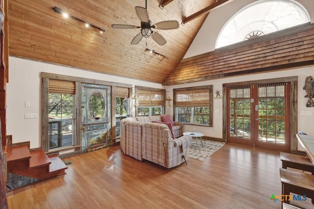 living room with high vaulted ceiling, ceiling fan, light hardwood / wood-style floors, wooden ceiling, and french doors