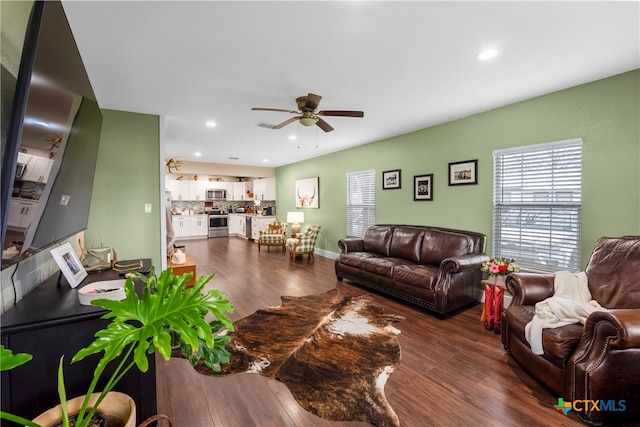 living room with dark wood-type flooring and ceiling fan