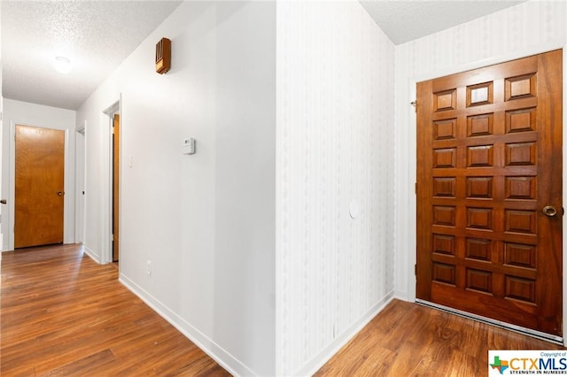 foyer entrance featuring a textured ceiling and hardwood / wood-style flooring