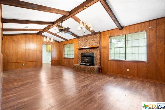 unfurnished living room featuring lofted ceiling with beams, wood-type flooring, and a wealth of natural light