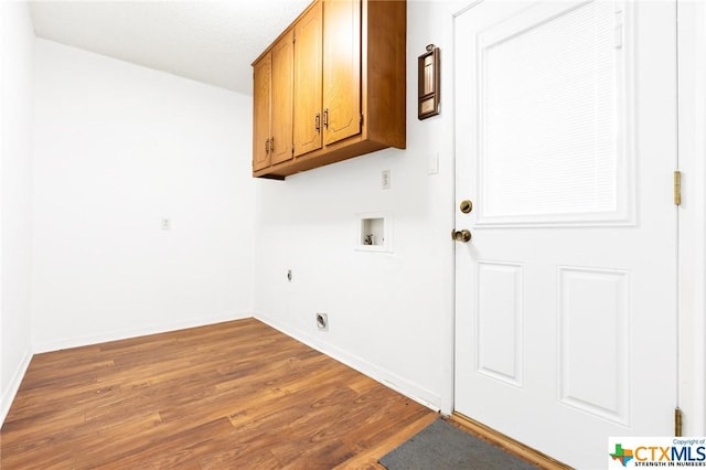 clothes washing area featuring cabinets, hookup for a washing machine, electric dryer hookup, and dark wood-type flooring