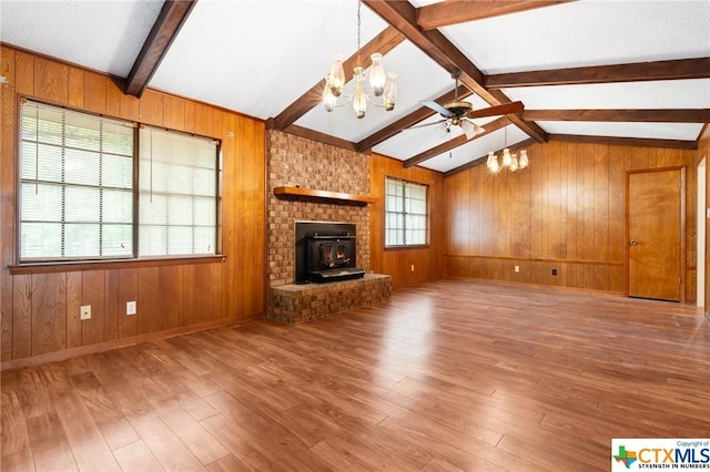 unfurnished living room with a wood stove, hardwood / wood-style floors, and a healthy amount of sunlight