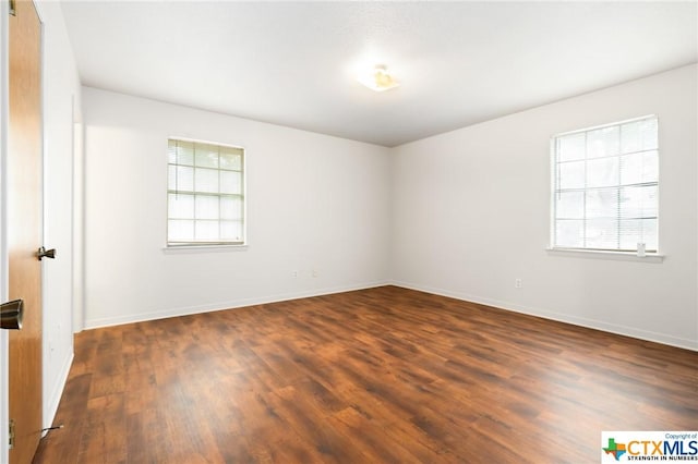 empty room with dark wood-type flooring and a healthy amount of sunlight