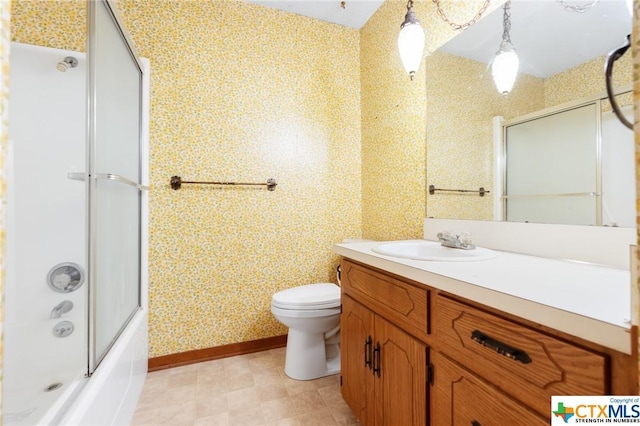 full bathroom featuring combined bath / shower with glass door, vanity, and toilet