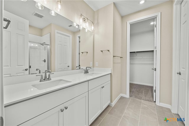 124 Jasmine Ln, Marble Falls, TX 78654 - full bath featuring a shower stall, double vanity, a walk in closet, baseboards, and tile patterned floors