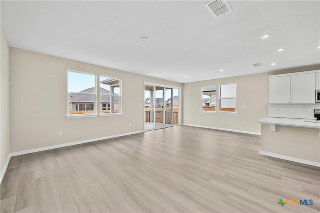 unfurnished living room with light hardwood / wood-style flooring and plenty of natural light