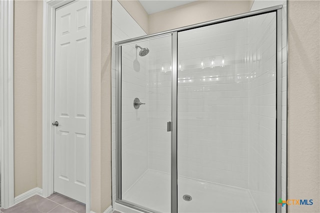 bathroom featuring tile patterned floors and a shower with door