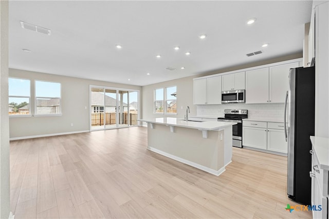 124 Jasmine Ln, Marble Falls, TX 78654 - kitchen with appliances with stainless steel finishes, light wood finished floors, a sink, open floor plan, and recessed lighting