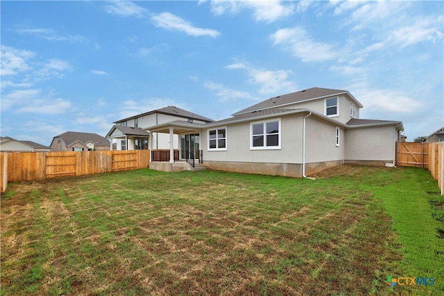 rear view of property featuring a yard