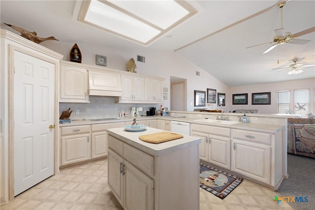 kitchen featuring sink, kitchen peninsula, dishwasher, and a kitchen island