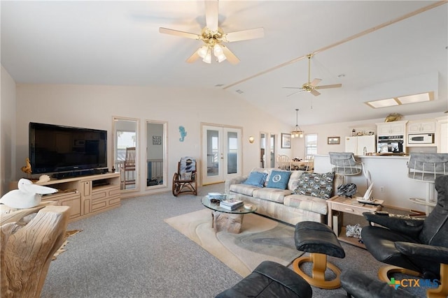 carpeted living room with french doors, ceiling fan, and vaulted ceiling