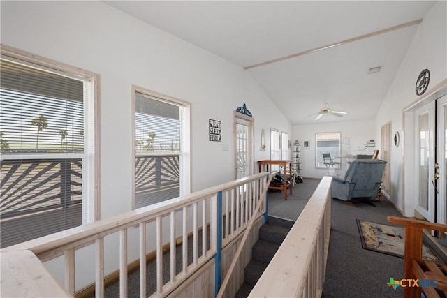 hallway featuring dark carpet and vaulted ceiling