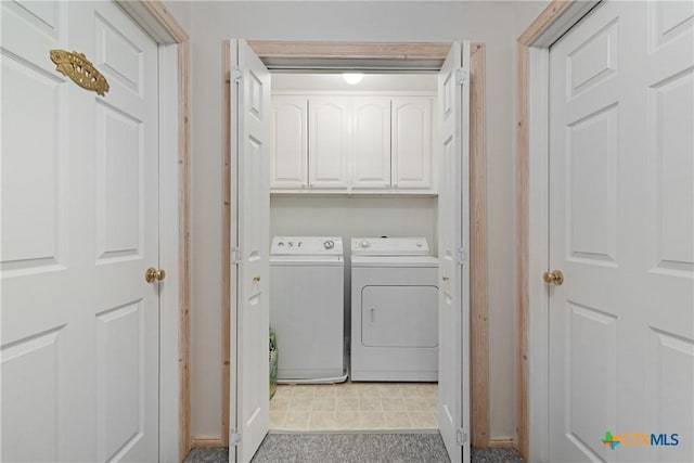 washroom featuring cabinets and independent washer and dryer