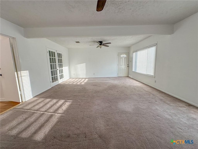 empty room with a textured ceiling, ceiling fan, light carpet, baseboards, and french doors