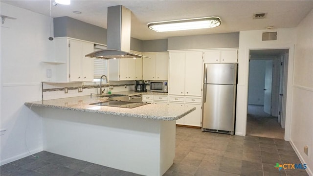 kitchen with white cabinets, a peninsula, island exhaust hood, stainless steel appliances, and a sink