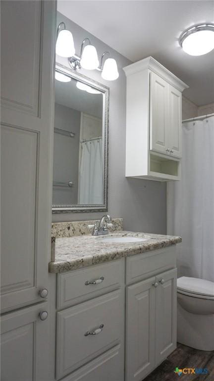 full bath with a shower with shower curtain, vanity, toilet, and wood finished floors