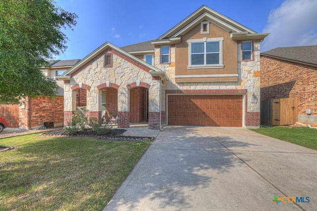 view of front facade with an attached garage, driveway, stone siding, and a front yard