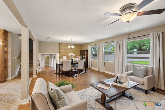 95 Mission Dr, New Braunfels, TX 78130 - living room featuring light wood finished floors, stairway, baseboards, and ceiling fan with notable chandelier