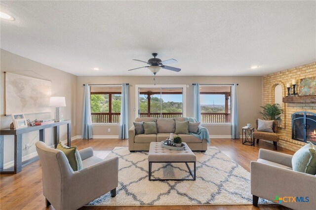 95 Mission Dr, New Braunfels, TX 78130 - living room featuring wood finished floors, recessed lighting, ceiling fan, a brick fireplace, and baseboards