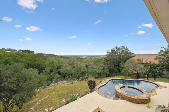 95 Mission Dr, New Braunfels, TX 78130 - view of swimming pool featuring a pool with connected hot tub, a wooded view, fence, and a patio area