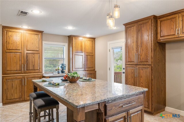 95 Mission Dr, New Braunfels, TX 78130 - kitchen featuring a healthy amount of sunlight, light stone countertops, visible vents, and brown cabinets