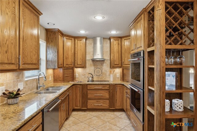 95 Mission Dr, New Braunfels, TX 78130 - kitchen featuring wall chimney range hood, stainless steel appliances, brown cabinets, and a sink