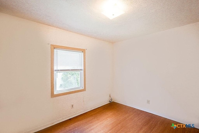 1707 S 43rd St, Temple, TX 76504 - empty room featuring wood finished floors, baseboards, and a textured ceiling