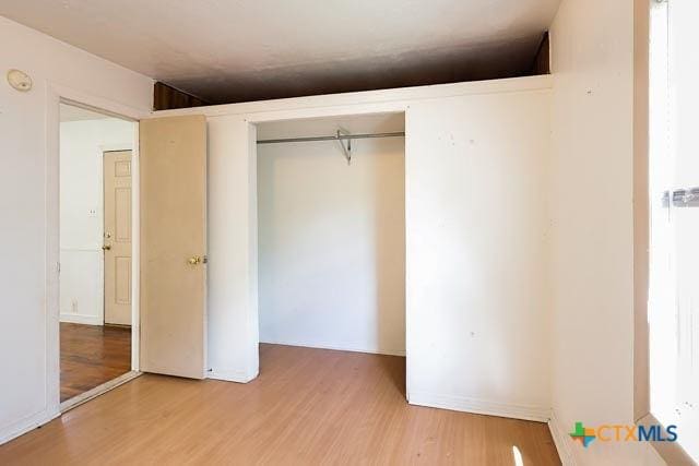 1707 S 43rd St, Temple, TX 76504 - unfurnished bedroom with wood finished floors and a closet