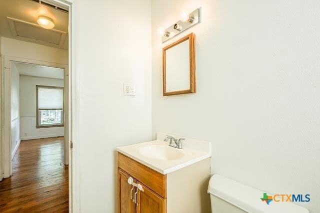 1707 S 43rd St, Temple, TX 76504 - half bath featuring toilet, vanity, and wood finished floors
