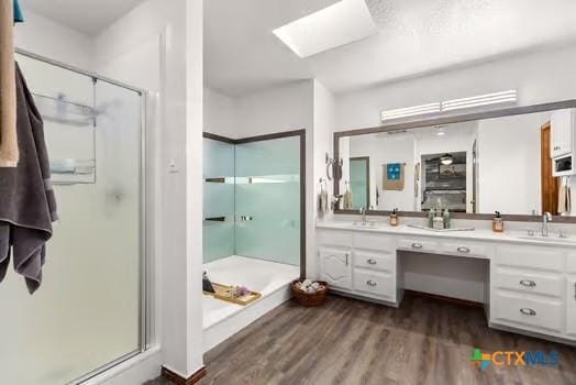 2305 Canyon Creek Dr, Temple, TX 76502 - full bathroom with a skylight, a stall shower, wood finished floors, and double vanity