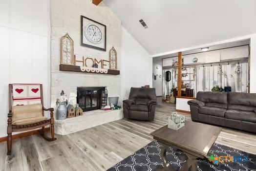 2305 Canyon Creek Dr, Temple, TX 76502 - living area with a large fireplace, wood finished floors, high vaulted ceiling, and baseboards
