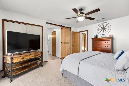2305 Canyon Creek Dr, Temple, TX 76502 - bedroom featuring light colored carpet, a barn door, and ceiling fan