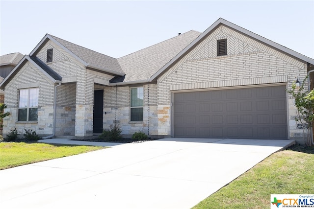 view of front of house with a garage and a front lawn