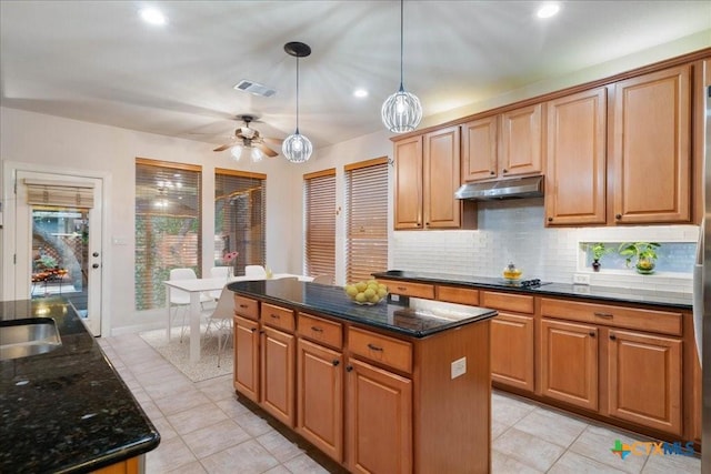 1800 Bluffwood Pl, Round Rock, TX 78665 - kitchen featuring under cabinet range hood, tasteful backsplash, light tile patterned flooring, a kitchen island, and decorative light fixtures