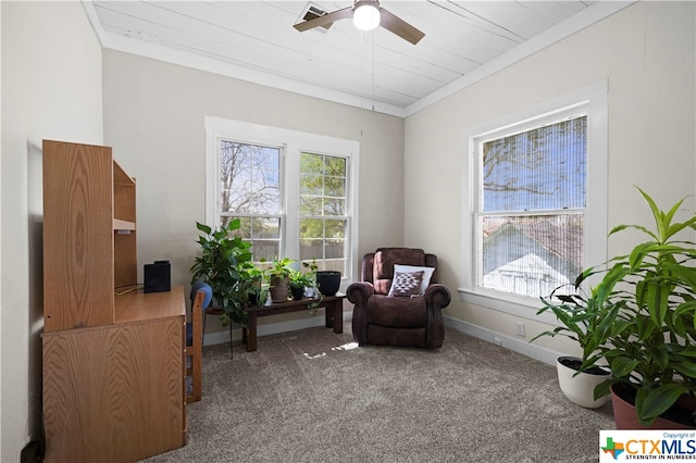 sitting room with a wealth of natural light, crown molding, and carpet floors