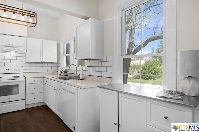 kitchen with white appliances, white cabinetry, sink, and a wealth of natural light