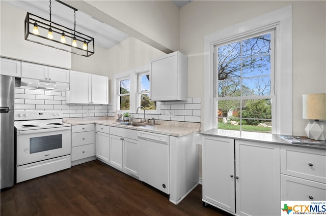 kitchen with dark wood-type flooring, white appliances, white cabinetry, and decorative light fixtures