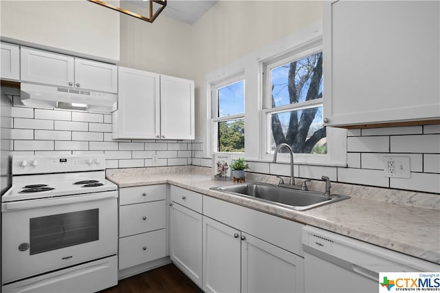 kitchen with white cabinets, sink, white appliances, and backsplash