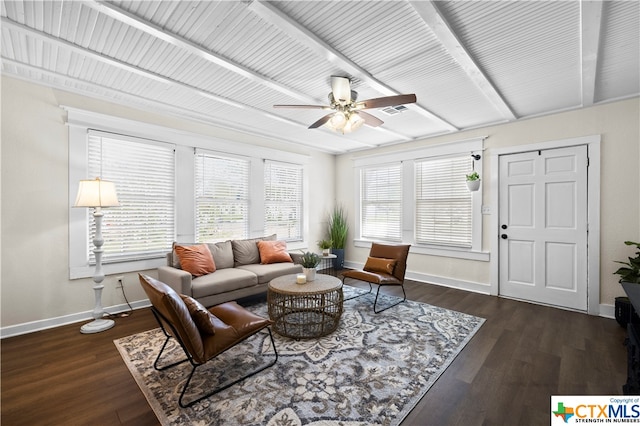 living room with dark wood-type flooring, ceiling fan, and a healthy amount of sunlight