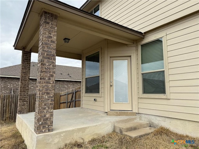 doorway to property featuring fence and a patio