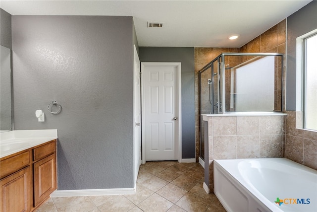 7631 Sterling Mnr, Converse, TX 78109 - bathroom featuring a garden tub, a stall shower, vanity, tile patterned floors, and a textured wall