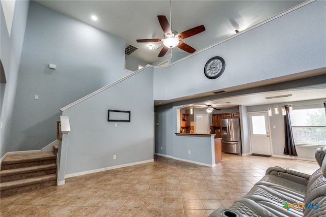 7631 Sterling Mnr, Converse, TX 78109 - unfurnished living room featuring a ceiling fan, stairway, and a high ceiling