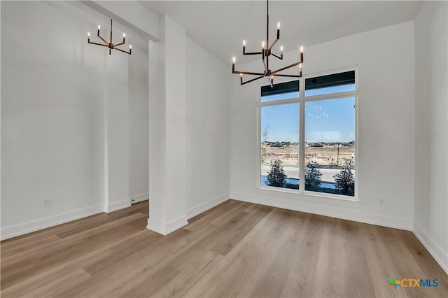 unfurnished dining area featuring light hardwood / wood-style floors and a notable chandelier