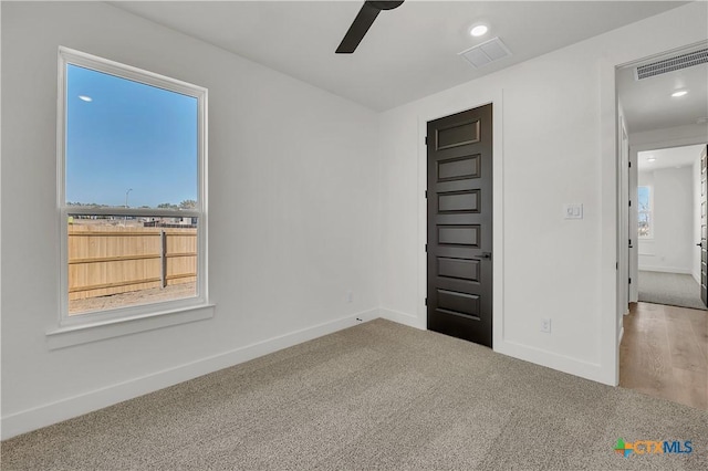 empty room featuring ceiling fan and carpet