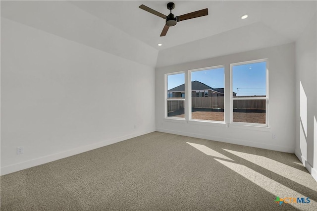 carpeted empty room featuring vaulted ceiling and ceiling fan