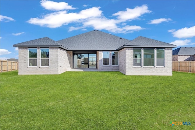 rear view of property with a lawn