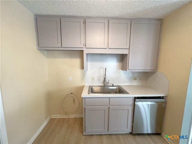 105 Kensington Dr, Victoria, TX 77901 - kitchen featuring stainless steel dishwasher, a sink, gray cabinetry, light wood-style flooring, and light countertops